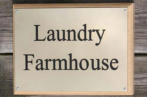 A polished brass nameplate on an oak backing board. Polished Brass Nameplate