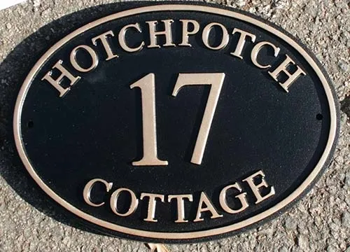 This sign also has a raised and painted border. Cast Oval Sign With House Number