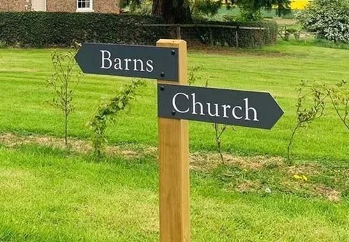 A wooden post with aluminium composite arrow signs. Simple Wooden Post